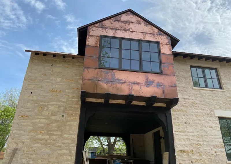Copper metal panel facade on a stone building for Skylight Installation in Burrillville