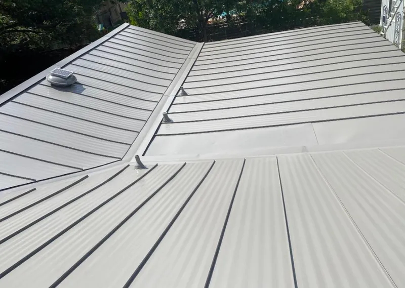 Solar attic fan installed on a metal roof for Roof Ventilation in Burrillville