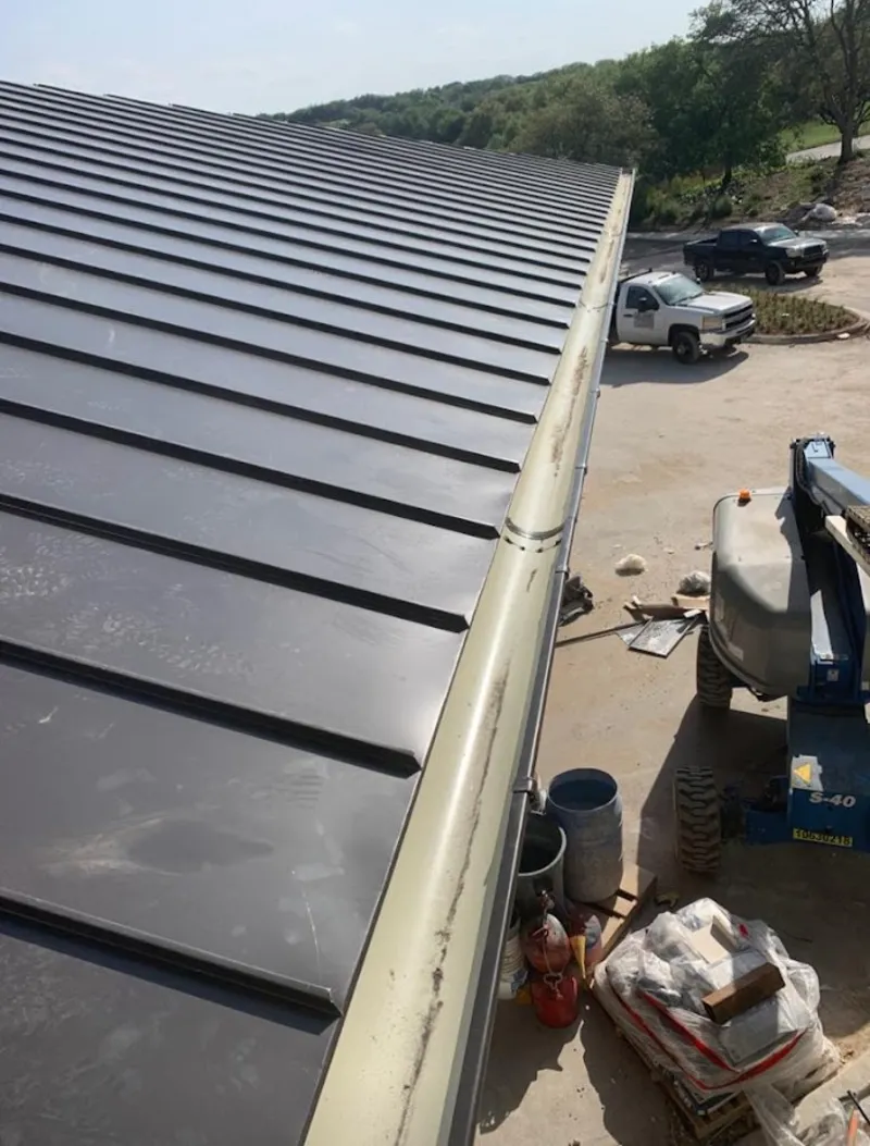 Standing seam panel and gutter detail on a metal roofing jobsite in Burrillville